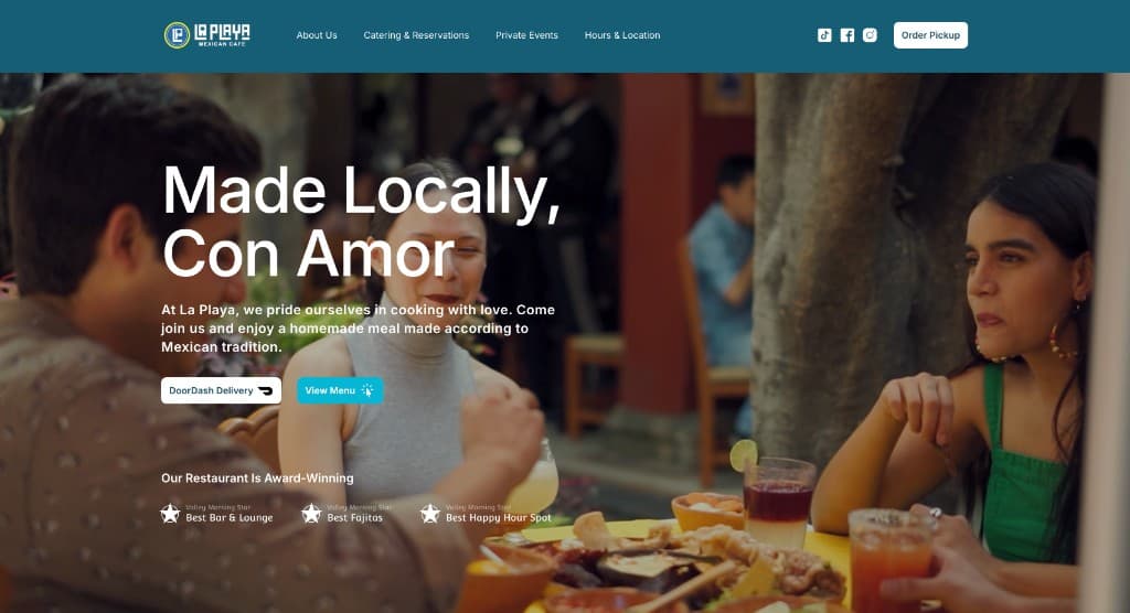 Restaurant website hero: dining scene with food and cocktails and headline Made Locally, Con Amor